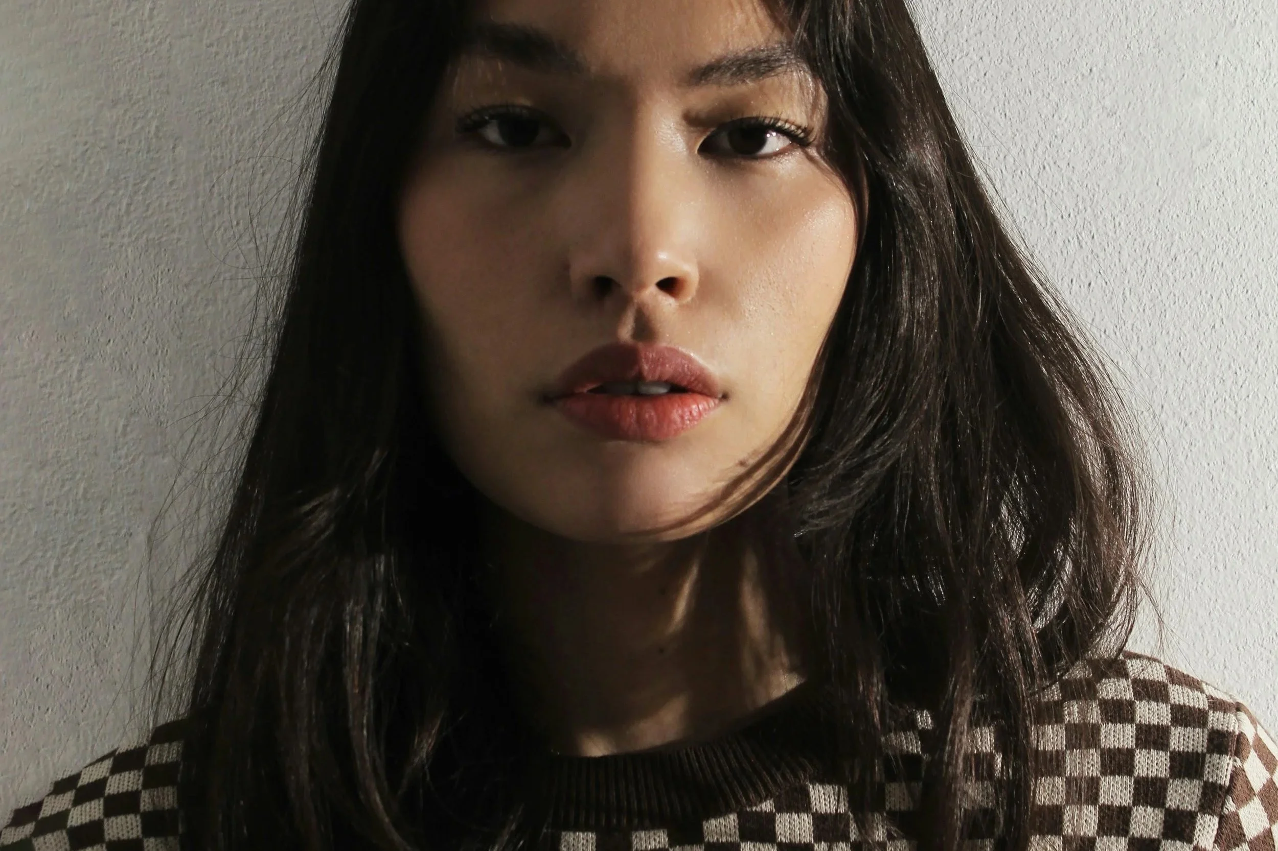 Close-up of woman with natural skin in soft directional light, highlighting texture, tone and subtle signs of low-level skin inflammation