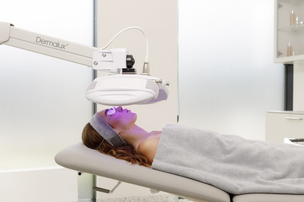 women relaxes under the Dermalux Tri-Wave MD infared