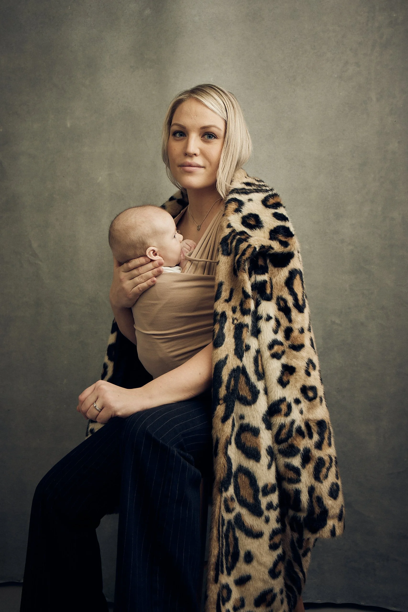 Mother holding her newborn close in a beige Najell Wrap baby carrier