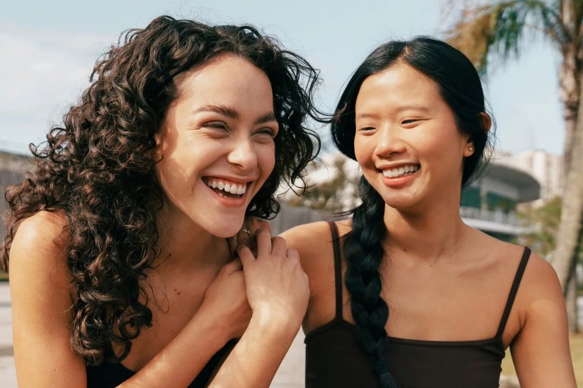 Two woman laughing and smiling with glowing skin from Hydrafacial