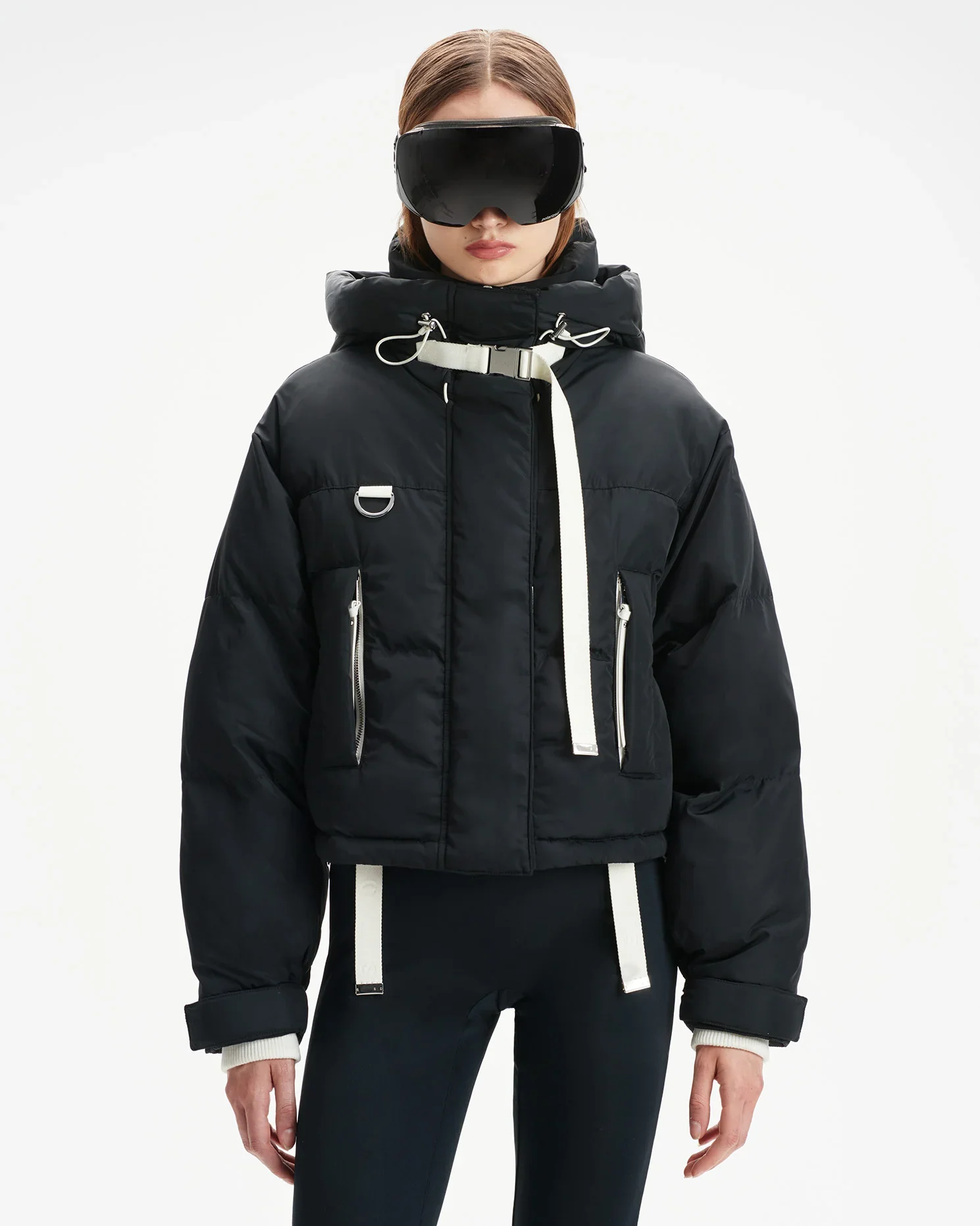 Female model wears Shorditch Ski Club ski jacket and ski goggles.