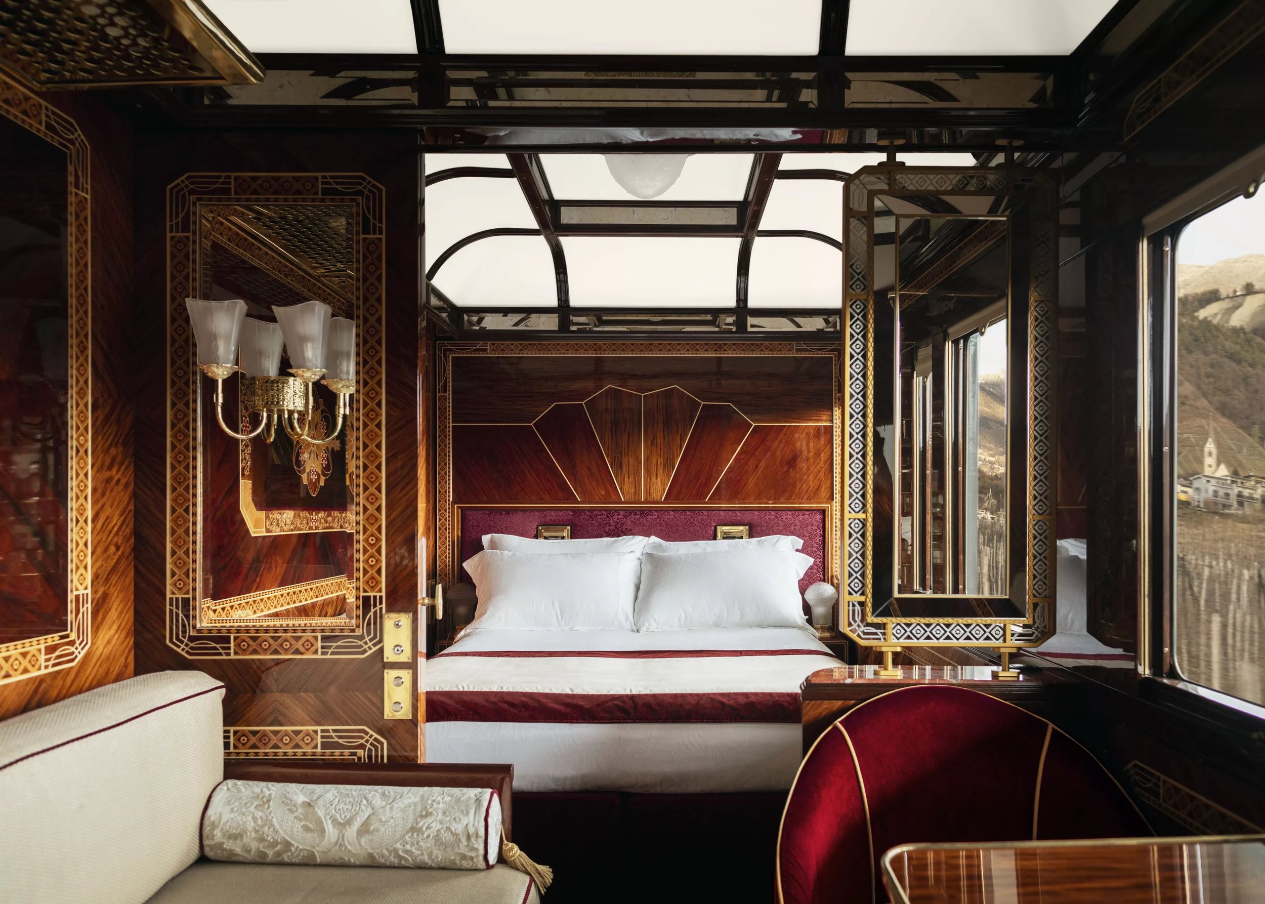 Luxury Grand Suite aboard Belmond's Venice Simplon-Orient-Express, featuring Art Deco wood panelling, a double bed and elegant interiors.