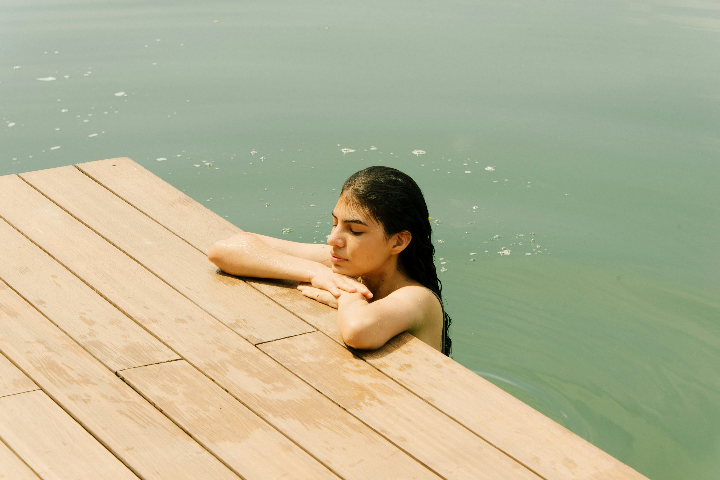 Woman resting in warm water, reflecting the calming, restorative approach of infra-red skin treatments