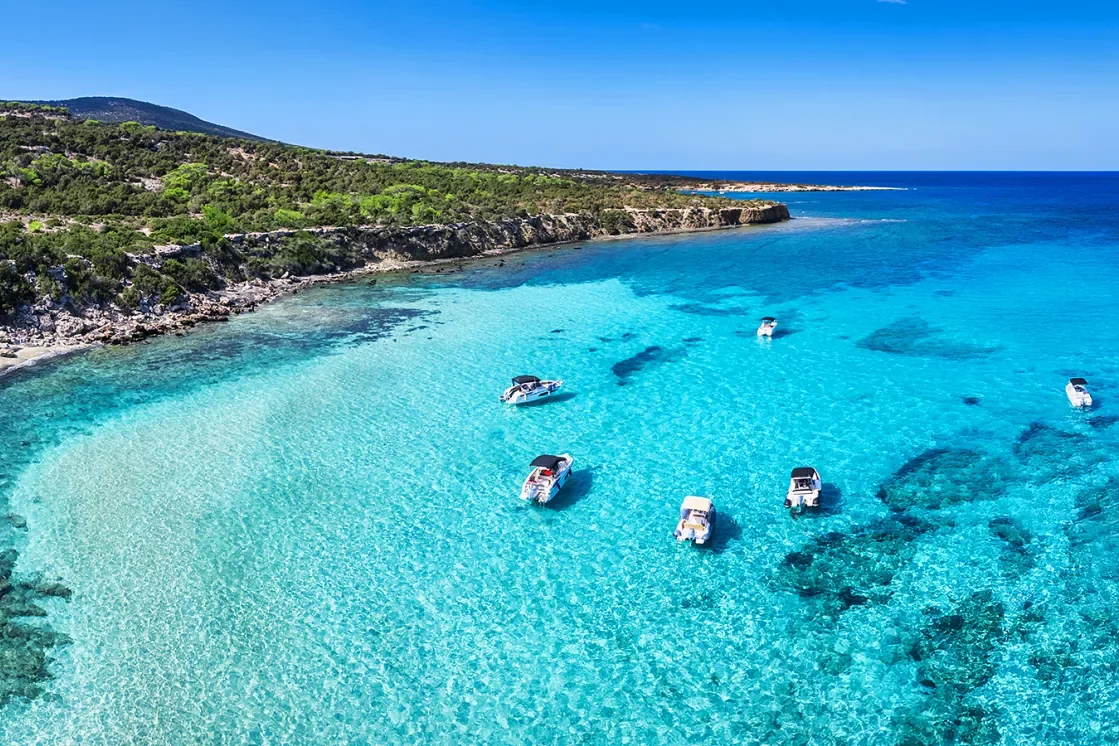 Clear turquoise water and small boats off the coast of Cyprus