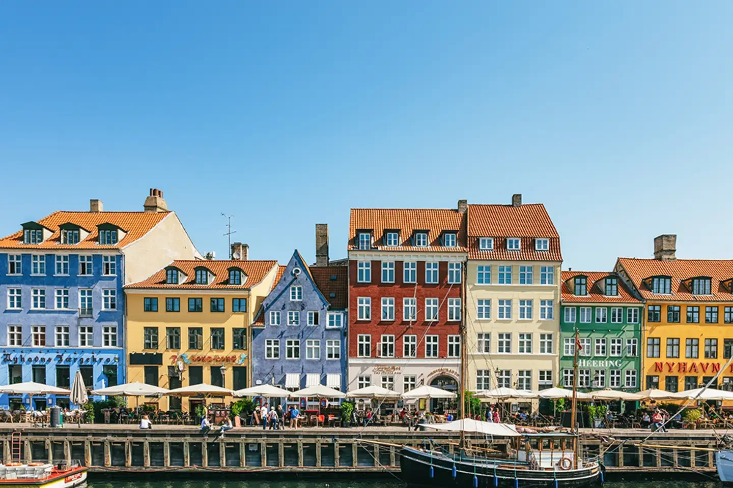 Colourful waterfront buildings lining Nyhavn harbour in Copenhagen during summer