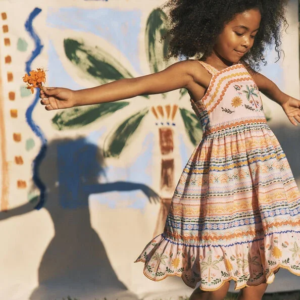 girl spins around wearing Monsoon's Summer Children’s Collection