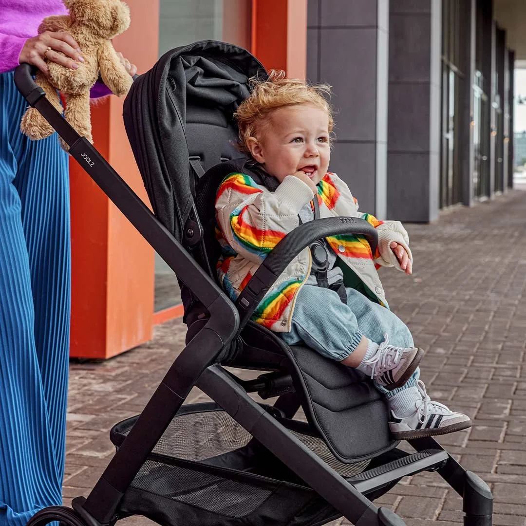 Toddler sitting comfortably in the Joolz Hub2 stroller during an everyday city outing
