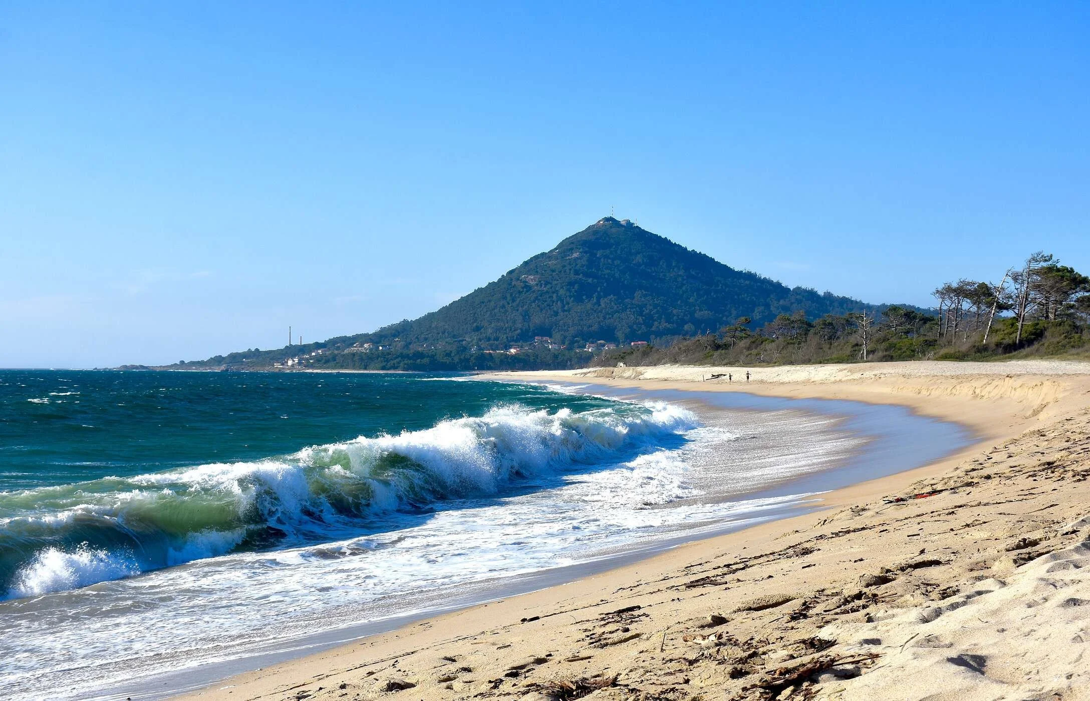 Wide Atlantic beach with rolling waves and mountain backdrop along Portugal’s northern coastline near Viana do Castelo