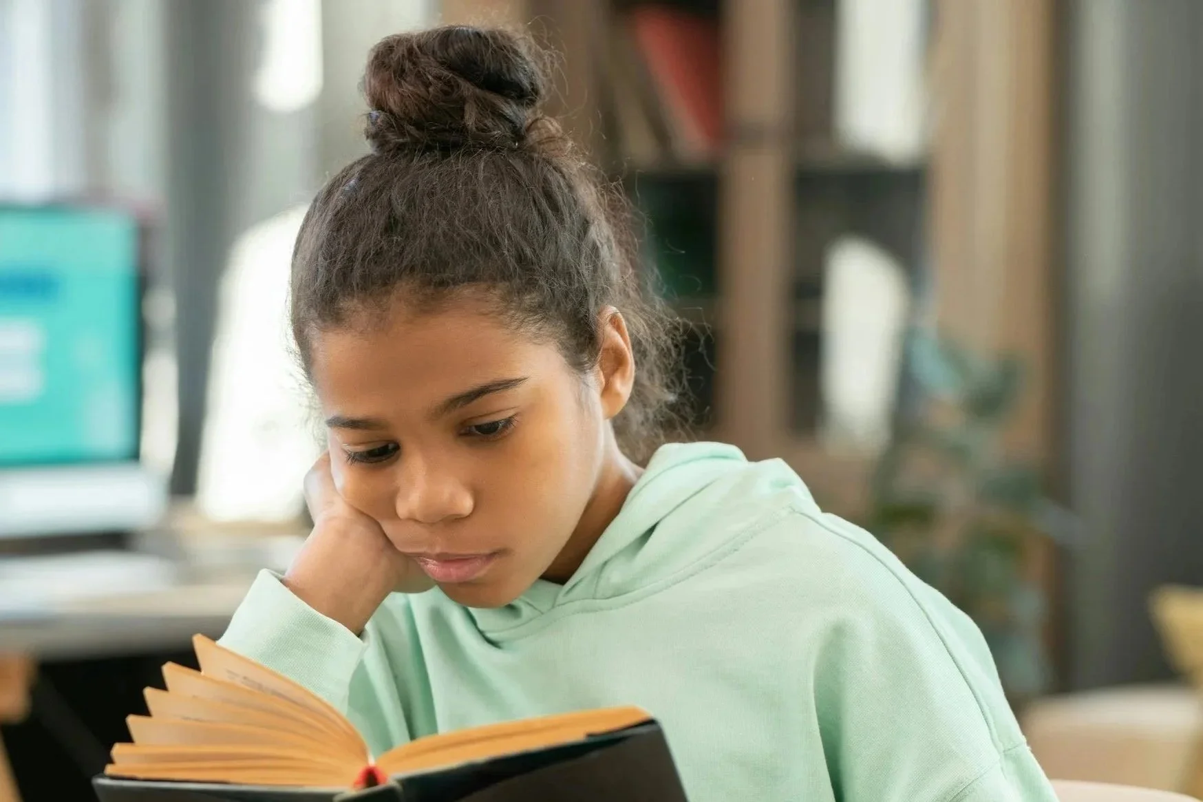 Child reading a book but looking thoughtful, illustrating how some children can read fluently but struggle with comprehension
