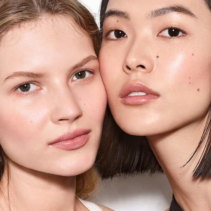 Two women with flawless skin wear Westman Atelier Vital Skin Foundation Stick (£62)