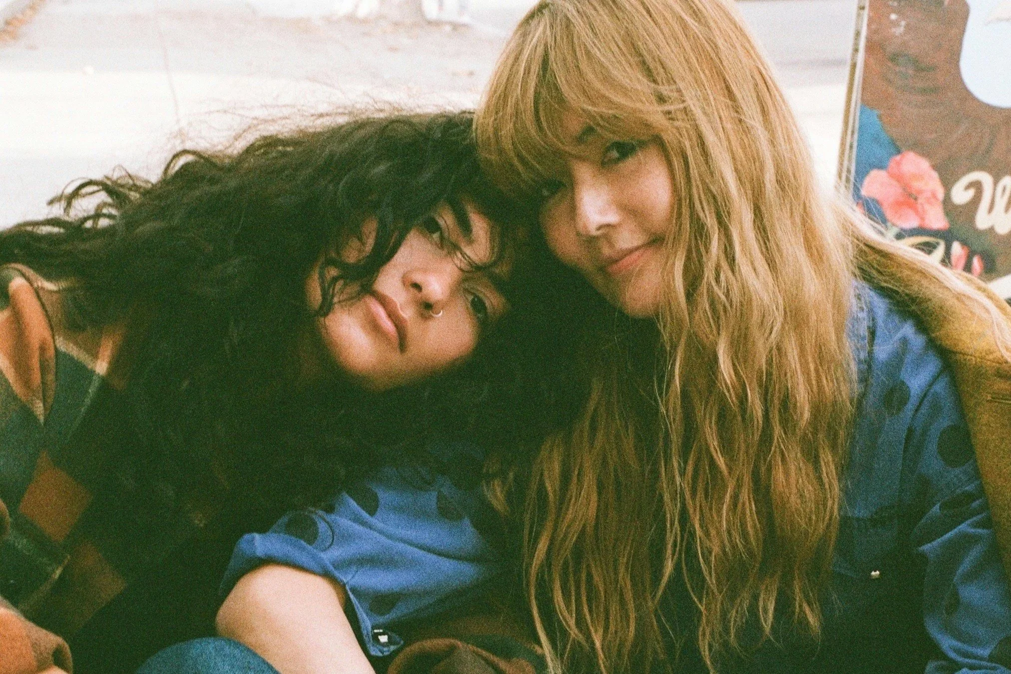 Two women with natural glowing skin in a warm late-summer setting, illustrating a September skincare routine transition.