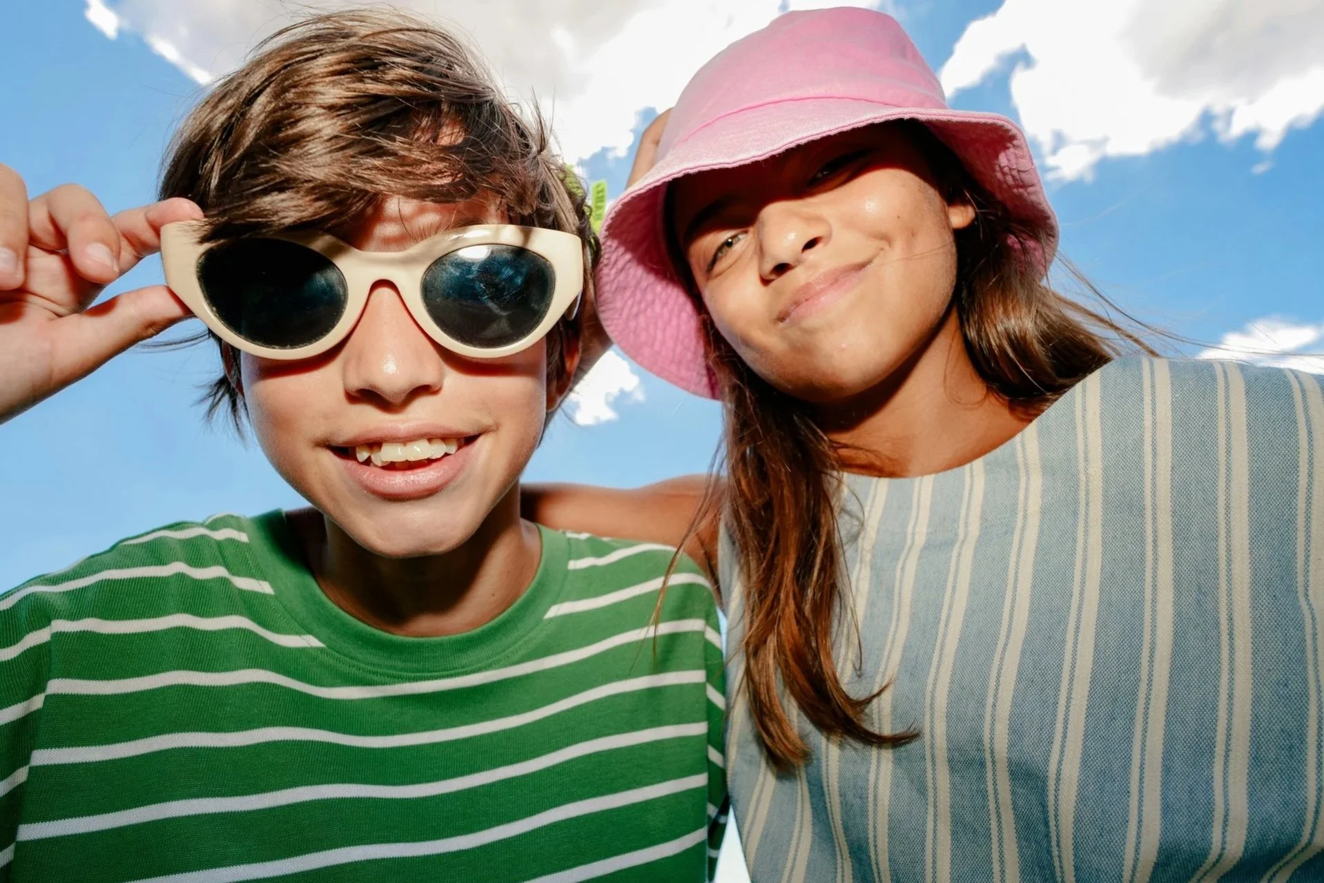 Teenagers wearing sunglasses in summer sunlight, representing balanced skincare support for hormonally reactive teenage skin and acne care.