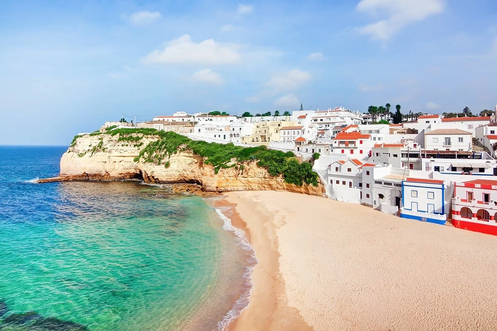 Sandy beach and whitewashed seaside village on Portugal’s Algarve coast.