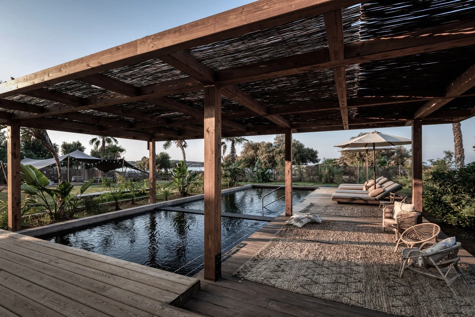 Shaded pool and natural wood interiors at Domes Zeen Chania in Crete.