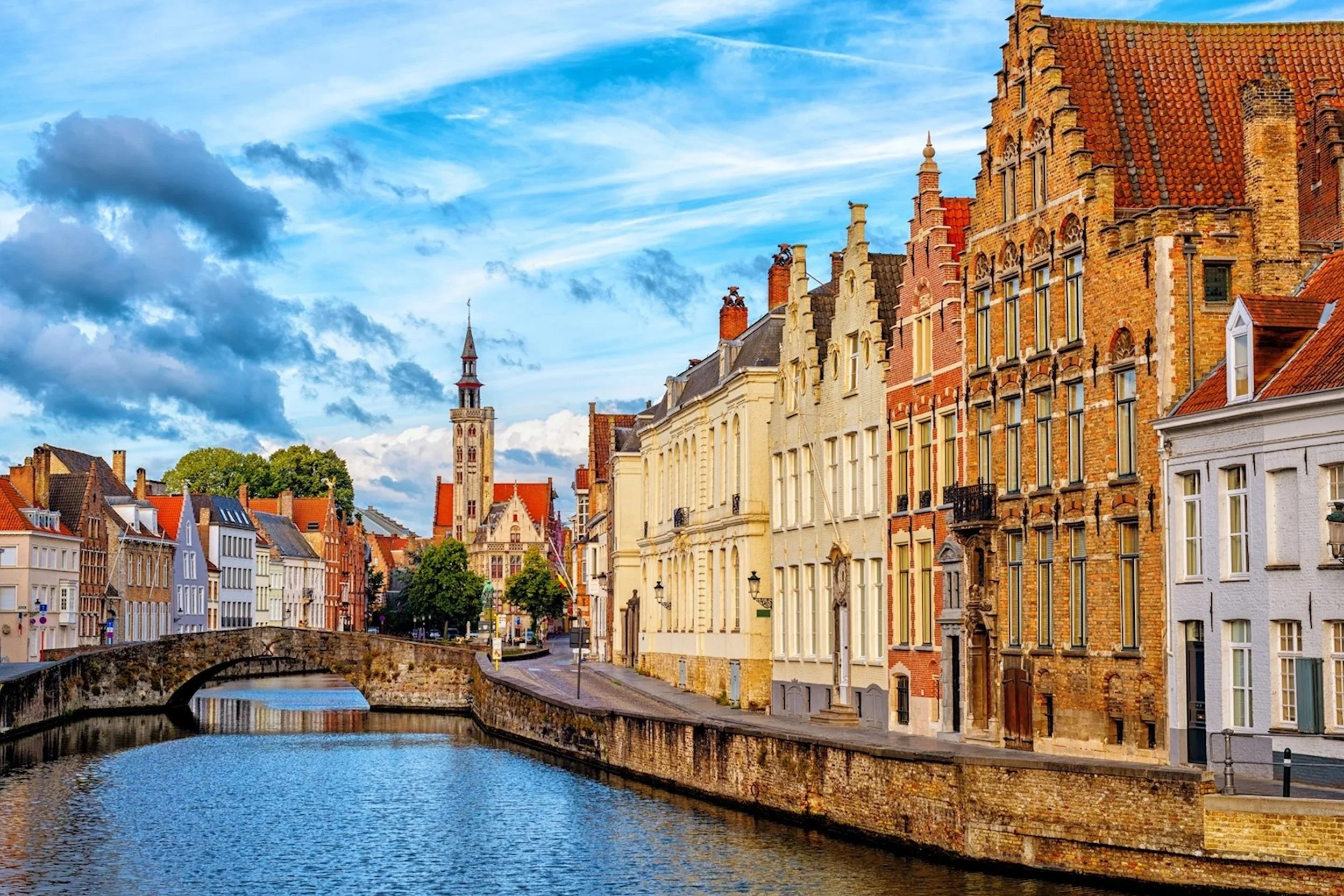Bruges, Belgium canal lined with medieval brick houses and cobbled streets in spring light