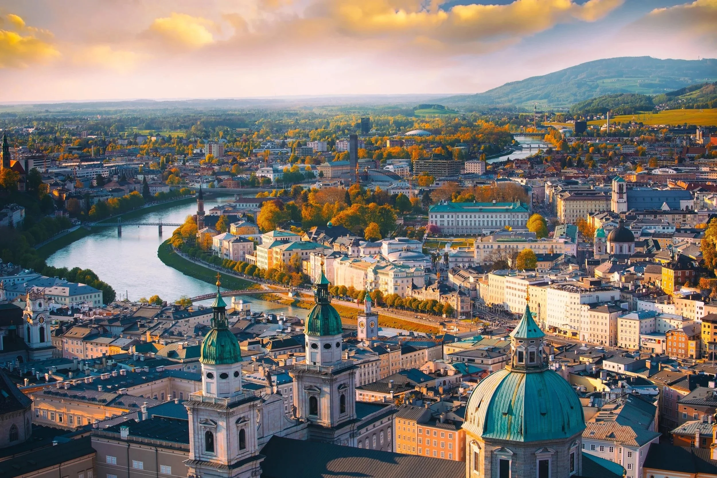 Panoramic view of Vienna’s historic city centre with church domes and the Danube Canal at sunset