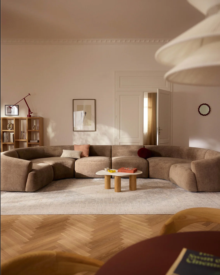 Westwing curved modular sofa in soft neutral fabric, designed in a U-shape to encourage social seating and relaxed living