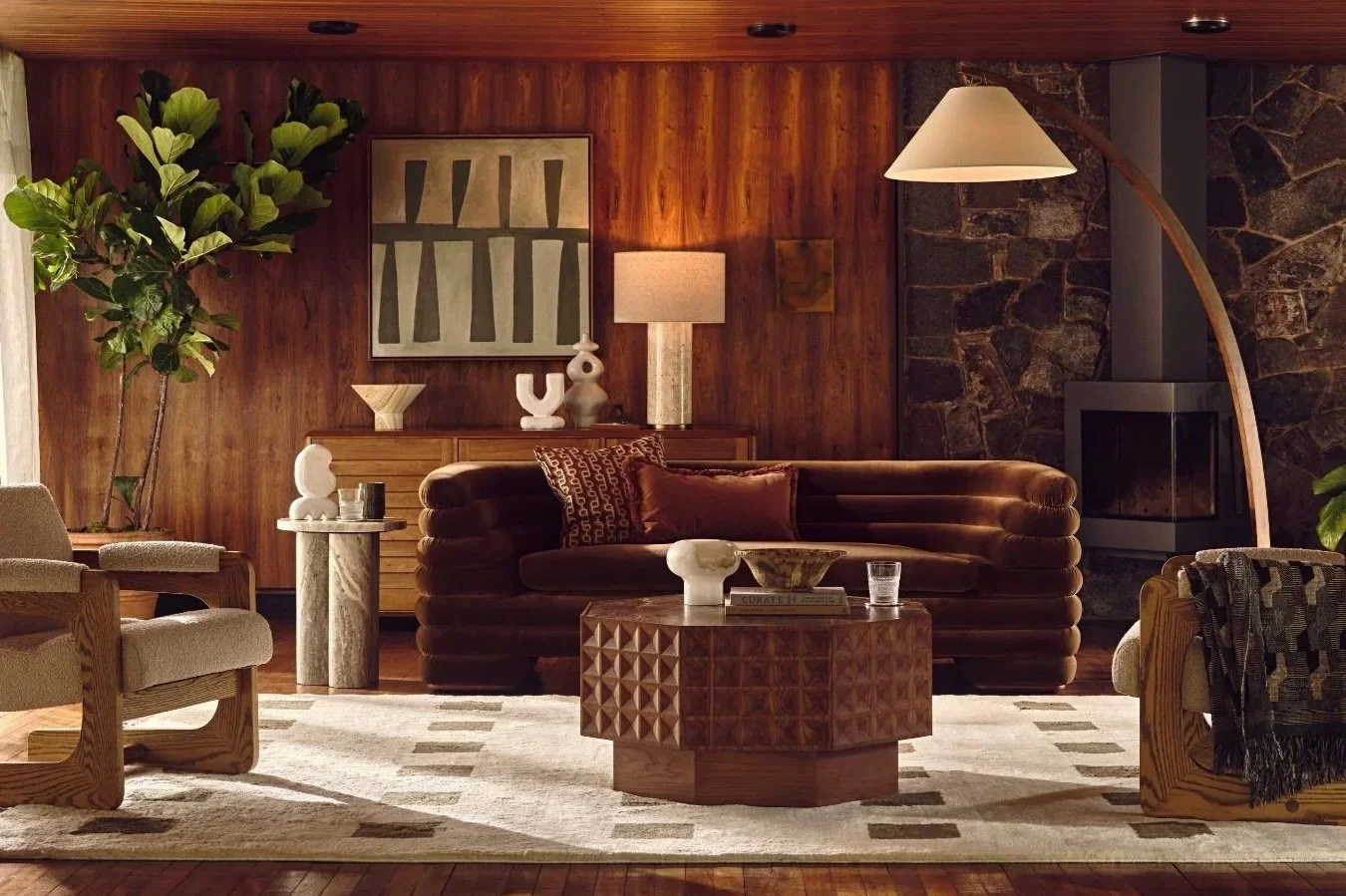 Cosy living room with layered lighting, table lamps and warm wood interiors creating soft ambient atmosphere by Soho Home