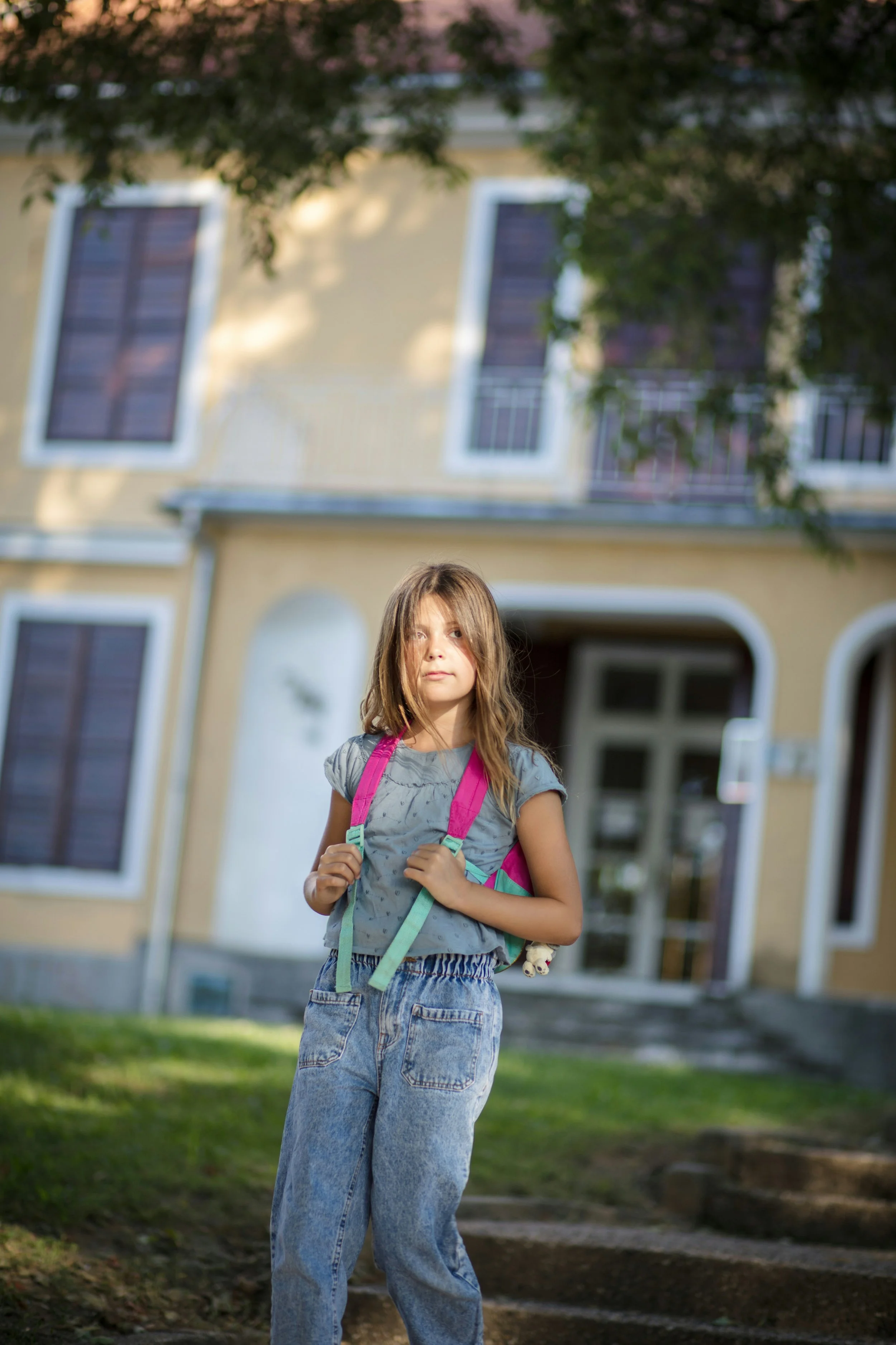 School-aged child wearing a backpack outside, moments before heading to school