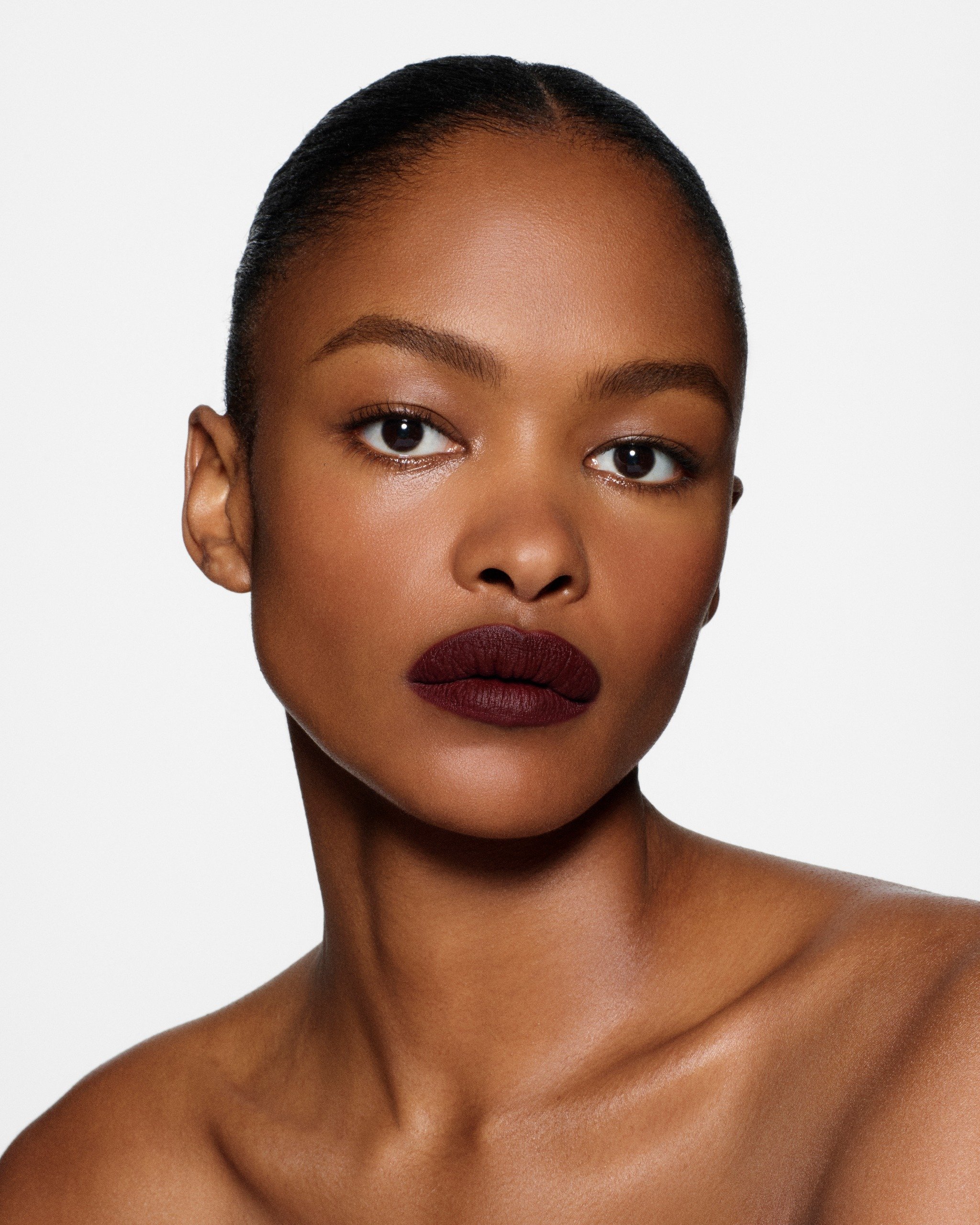Victoria Beckham Beauty model wearing deep burgundy lipstick and softly defined eyes.