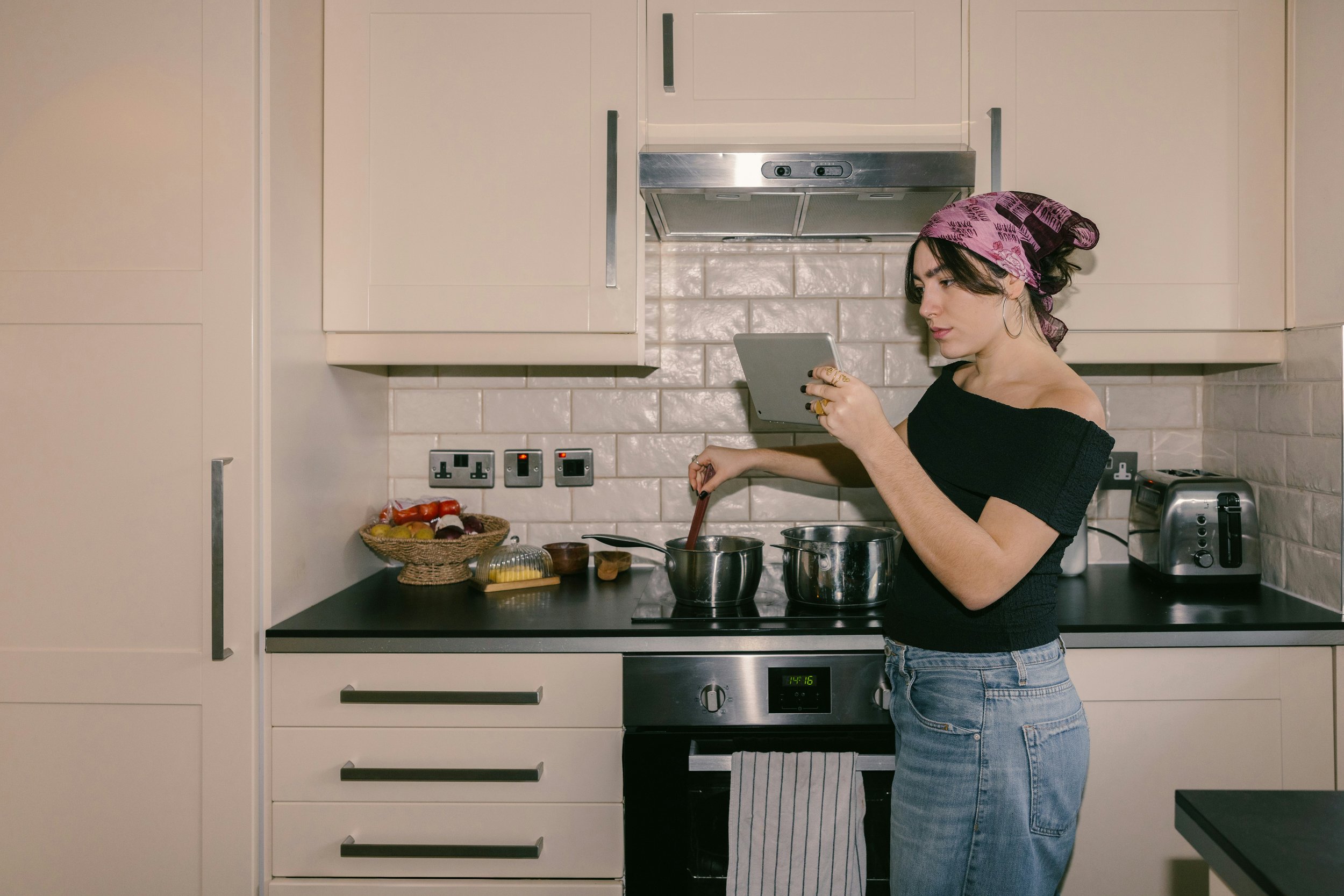 Woman preparing a healthy meal while reading nutrition advice on a tablet