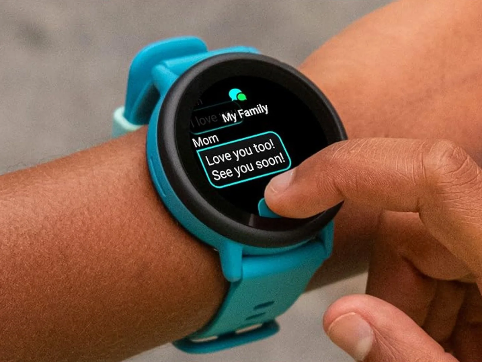 Child using the Garmin Bounce 2 smartwatch messaging feature on a turquoise watch.