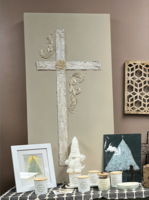 Wall art of a white cross on gold canvas with texture