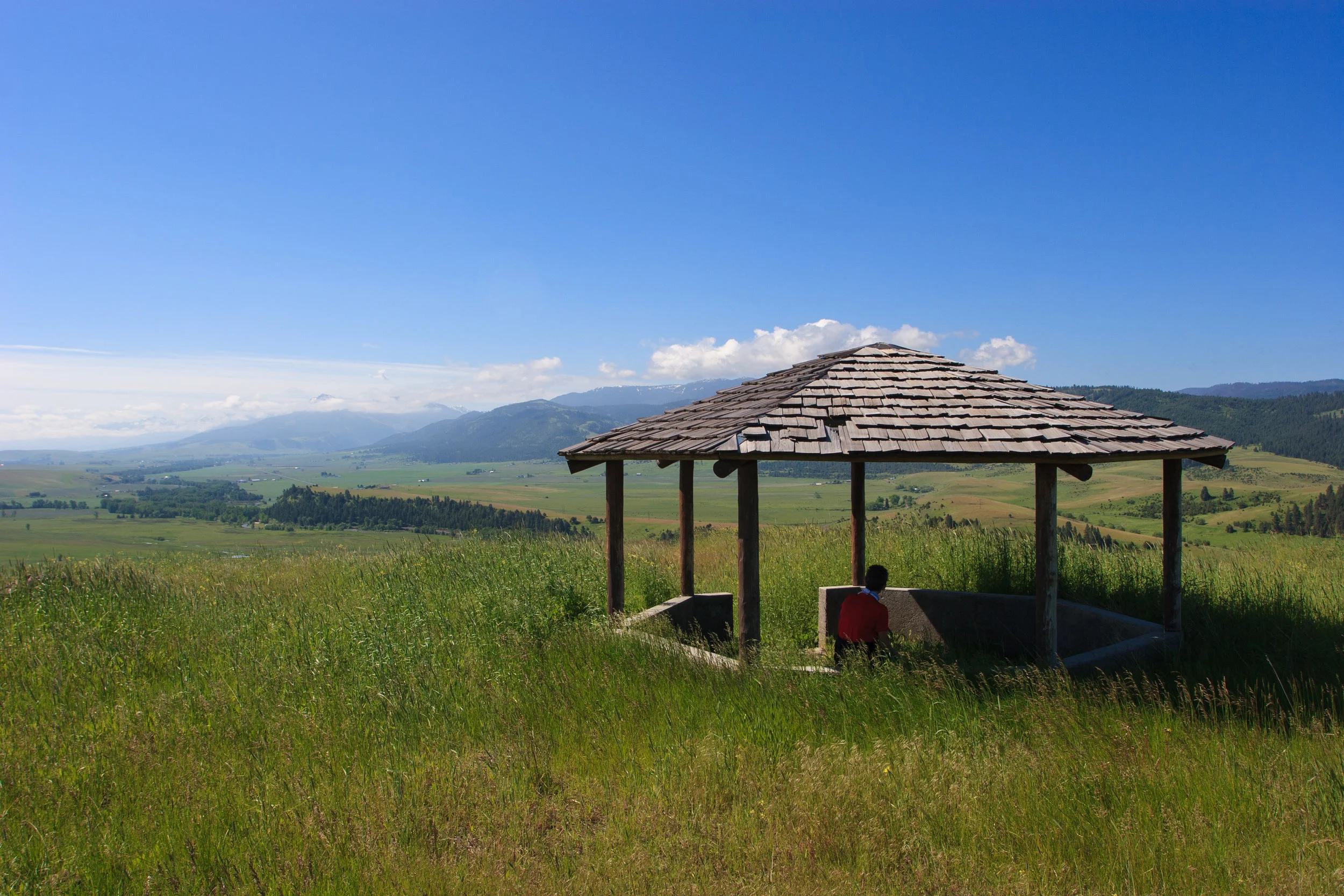 A visitor rests in the gazebo overlooking the Wallowa Valley