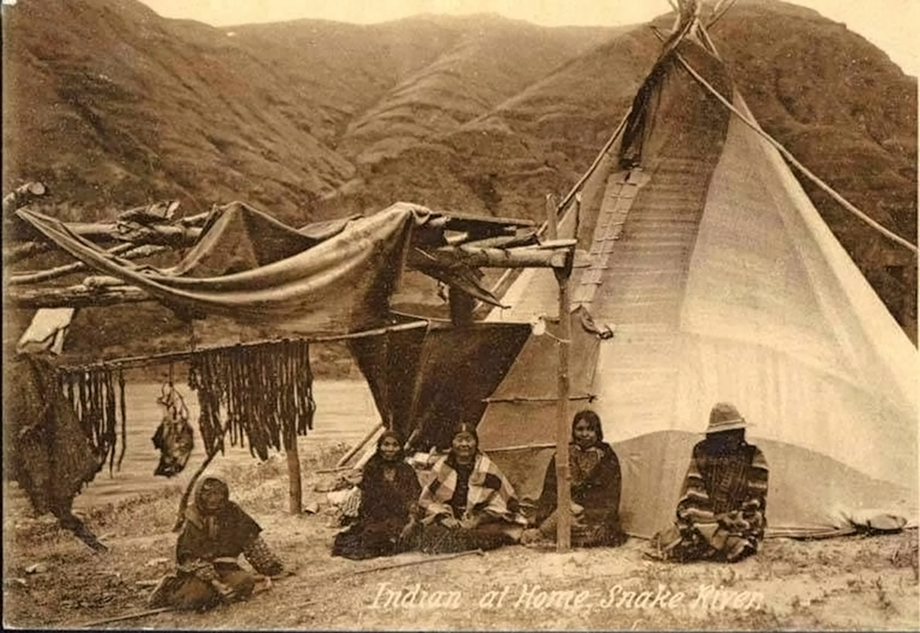 A family drying hé·su (eels/pacific lamprey) along the Snake River, 1902