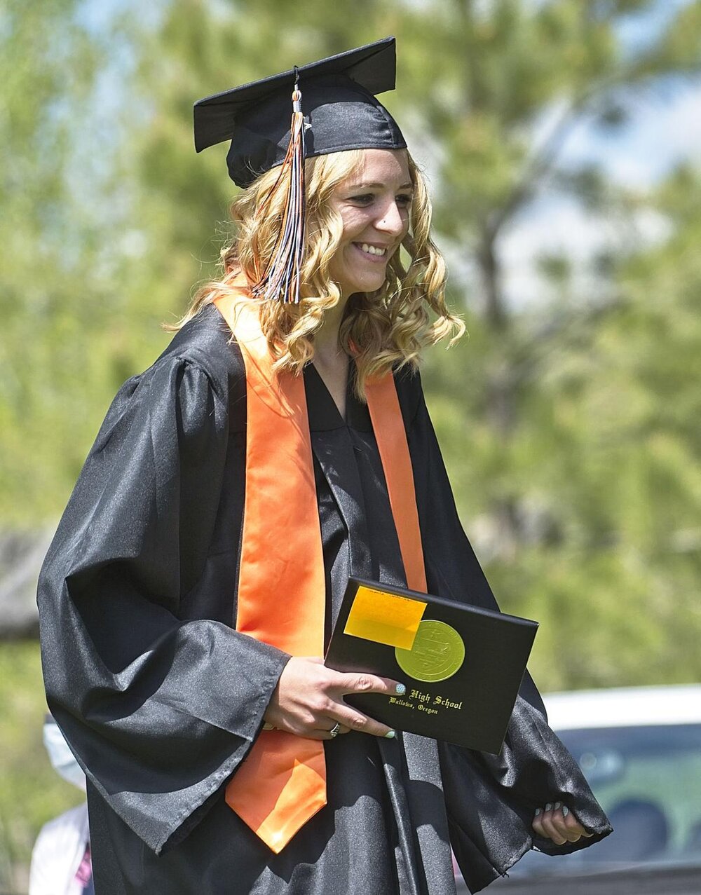  Jamie Johnston sports a wide grin as she carries her diploma back to her position on the Tamkaliks grounds.  