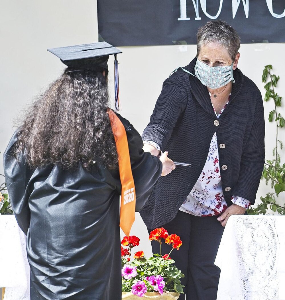  Alani Sang receives her diploma from school board vice chairwoman Martha Stevens.  