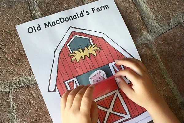 Fun and free kids farm activities, picture of a child playing with a peekaboo barn.