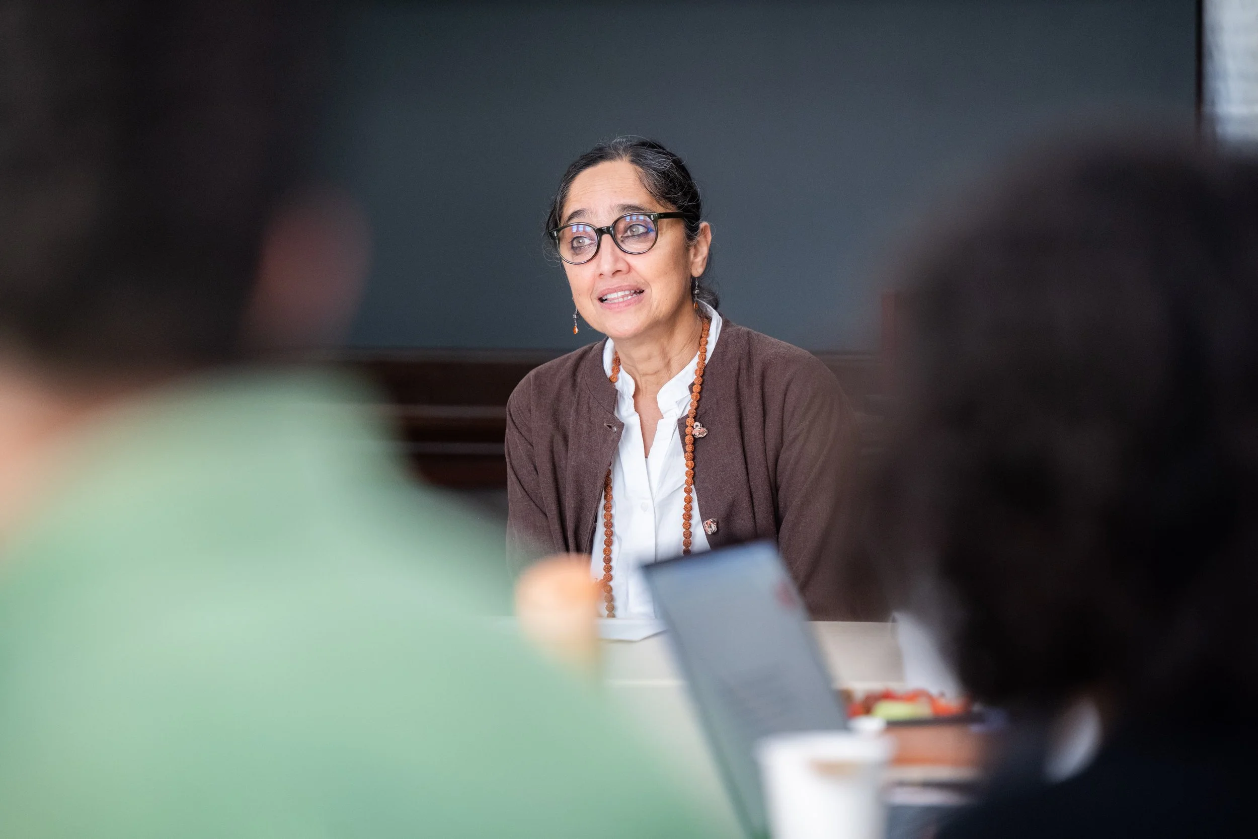 A thoughtful speaker engages a small group in an academic seminar, offering insight and discussion in a focused, collaborative learning environment.