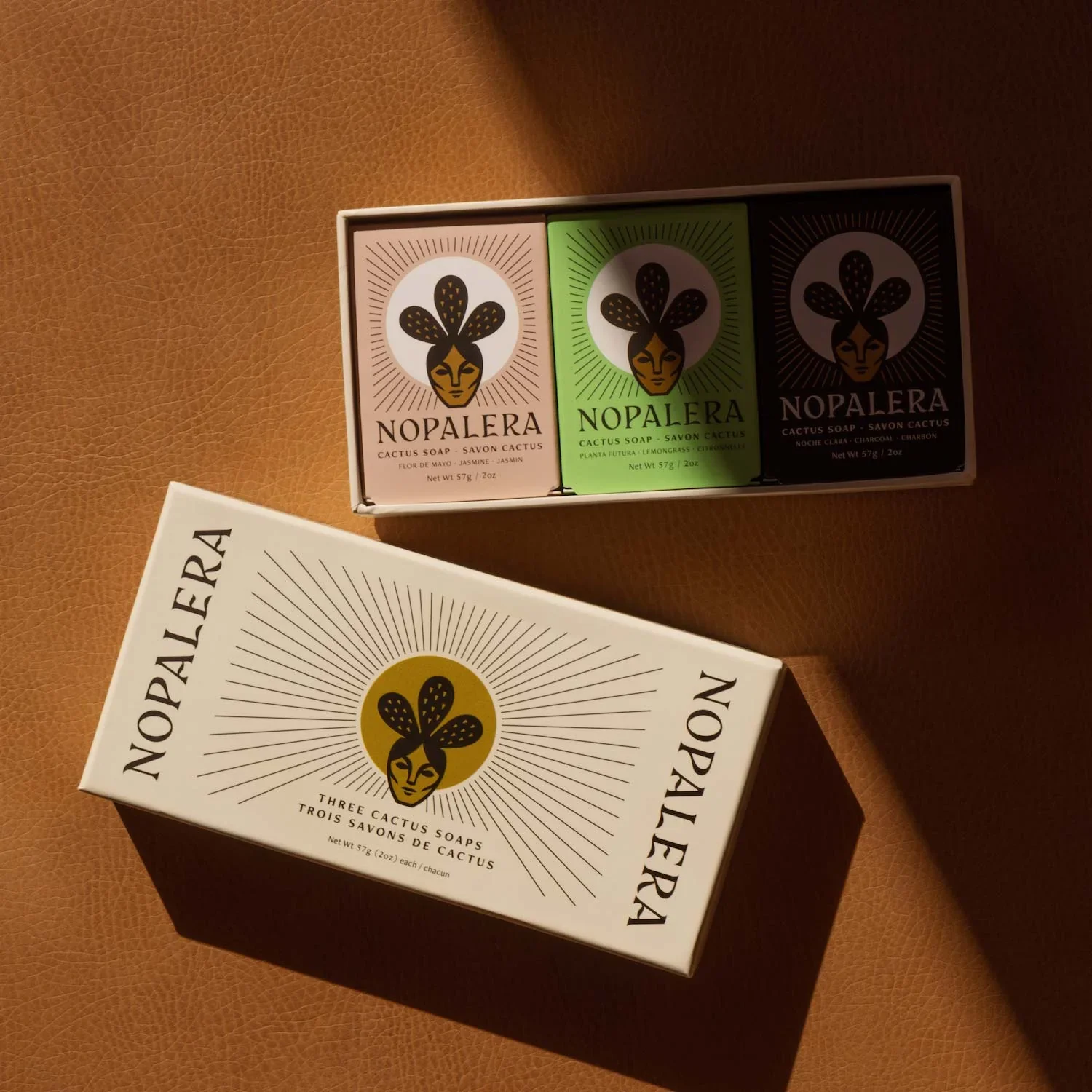 A Nopalera mini cactus soap trio is arranged on a leather surface, showcasing the brand’s women-owned, ethically made skincare powered by nopal cactus.