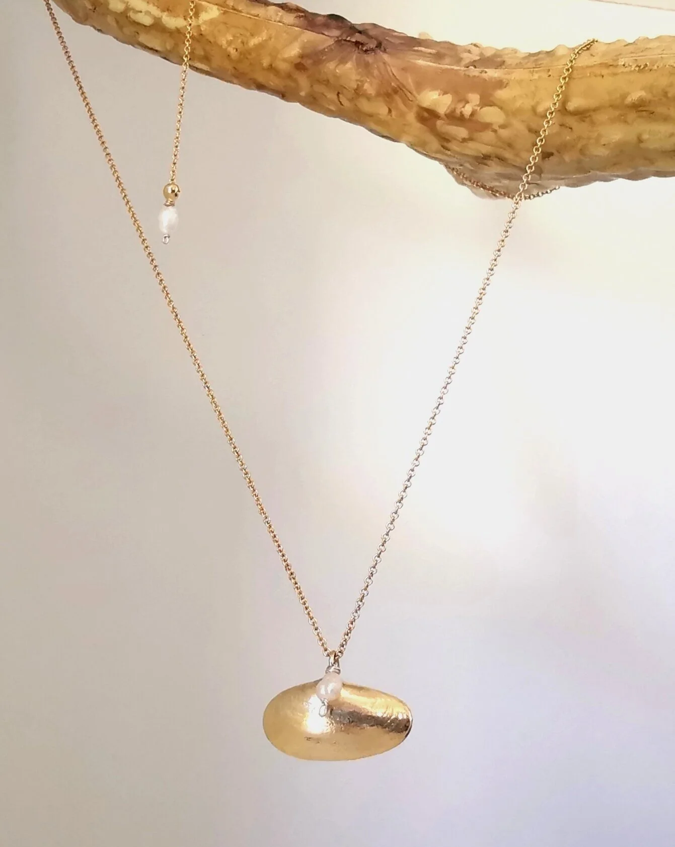gold necklace with a pearl