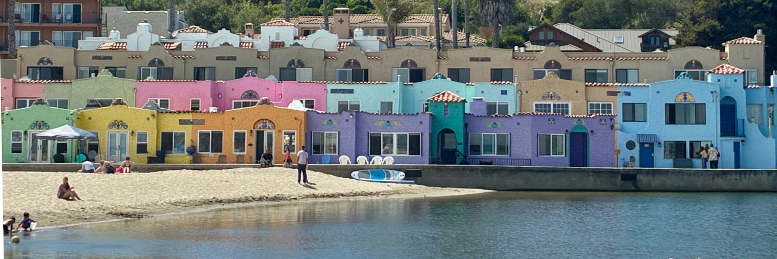 Colorful beachfront homes line the shore in Capitola Village, California, on a sunny afternoon.