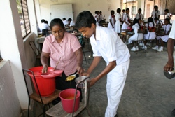 One of the cooks helps to serve food to older classes to ensure everyone gets a fair share