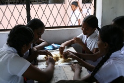 Girls sharing the food using a “newspaper plate”