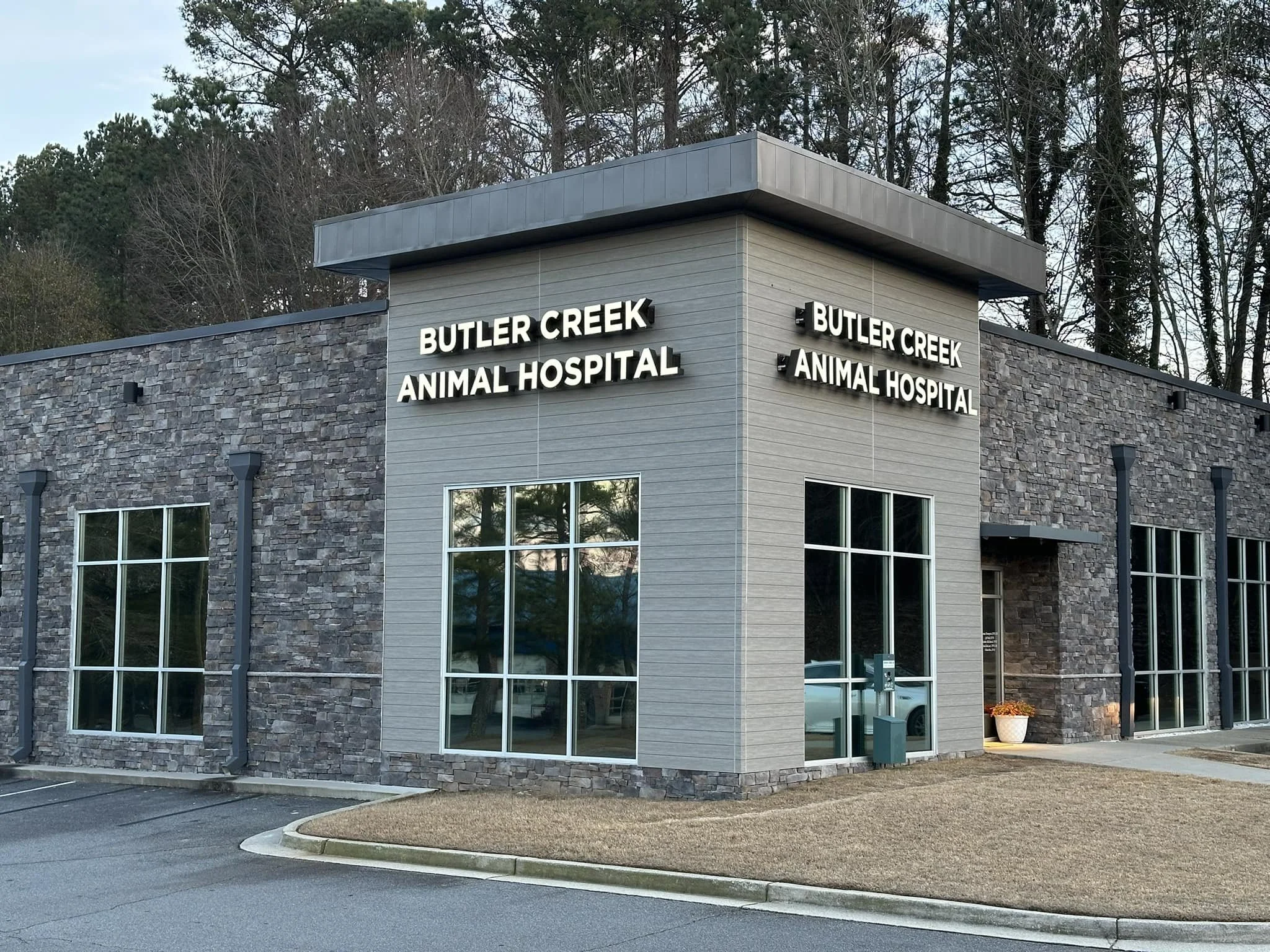 Exterior view of Butler Creek Animal Hospital building with stone and gray siding, large windows, and white signage.