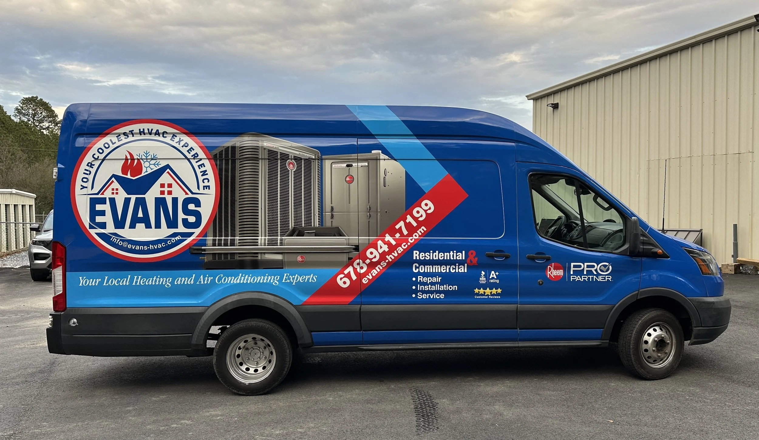 Blue van with Evans HVAC business branding, phone number, and services listed, parked outside near a beige building and other vehicles.