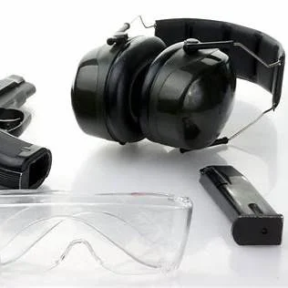 Gun, earmuffs, safety goggles, and a magazine on a white background