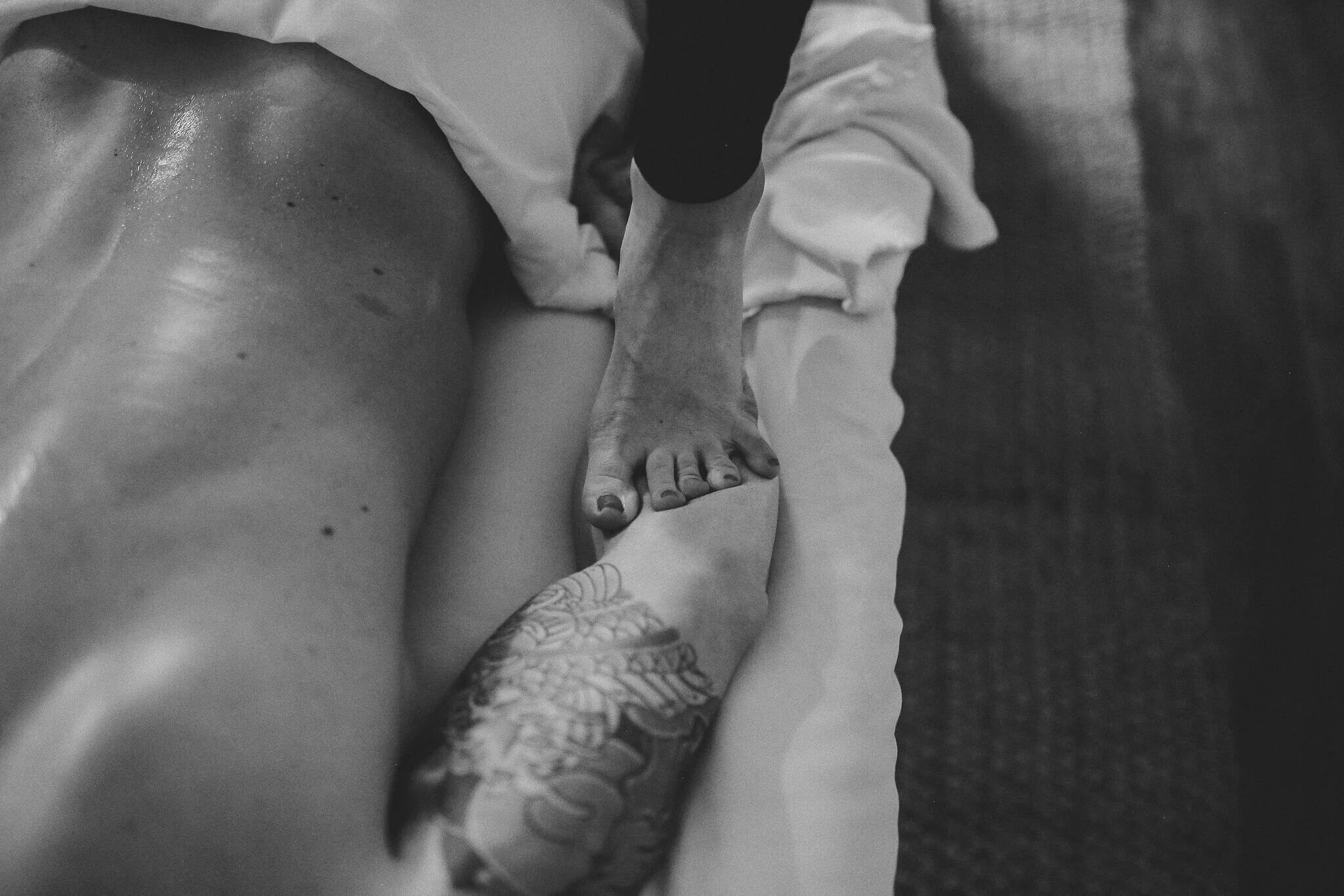 Massage therapist uses her feet to provide a ashiatsu massage for deep tissue relief for an athlete for sports recovery in Wheat Ridge, CO.