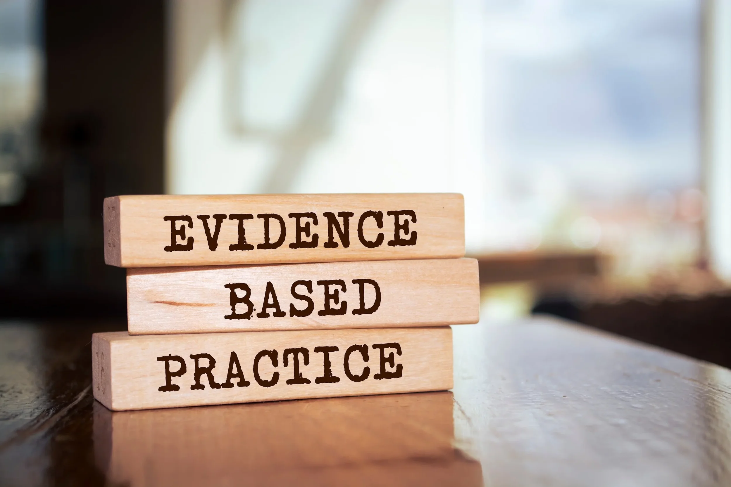 Wooden blocks stacked with the words "Evidence Based Practice" printed on them.