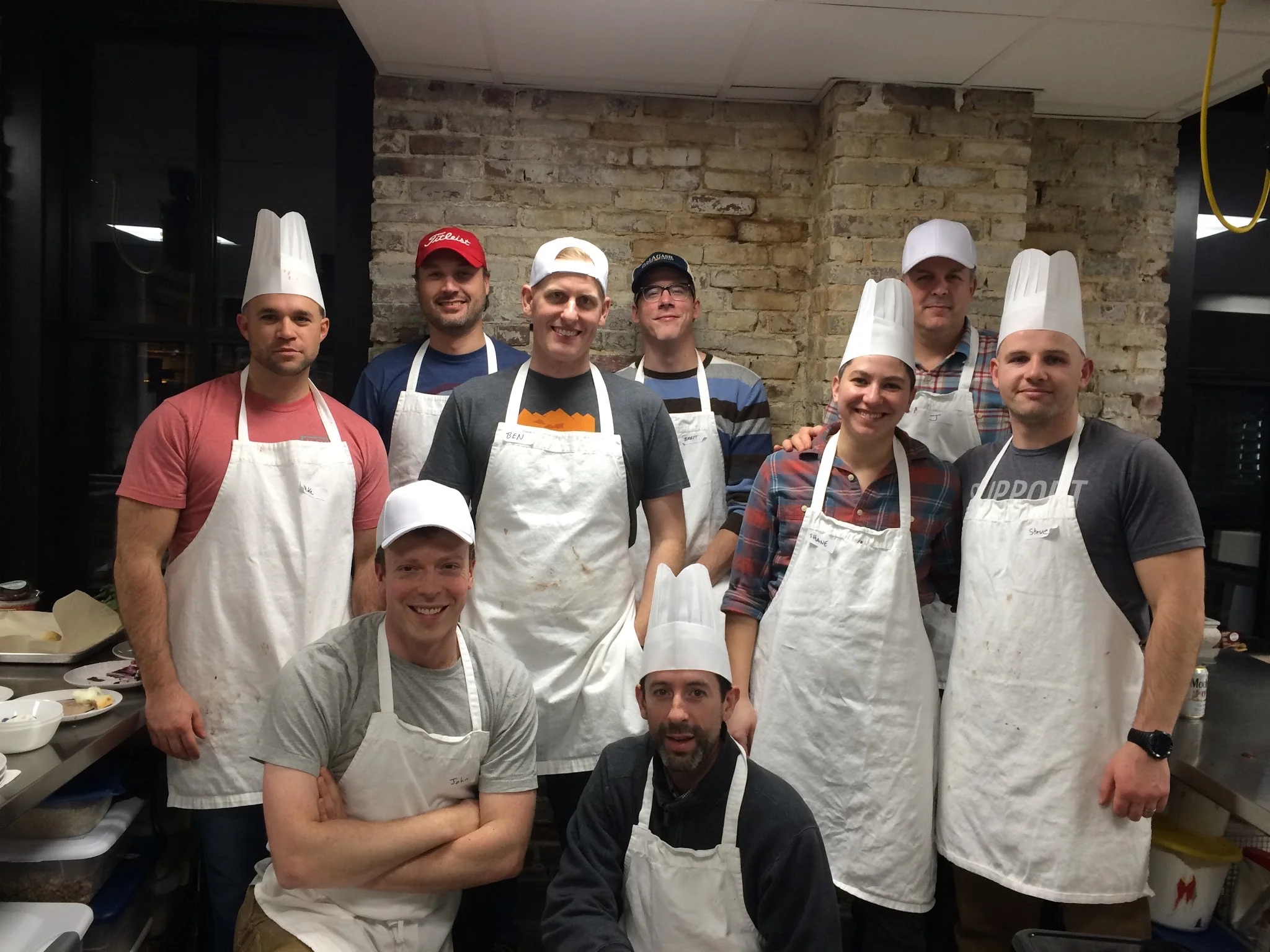 Bachelor party cooking competition group in professional kitchen
