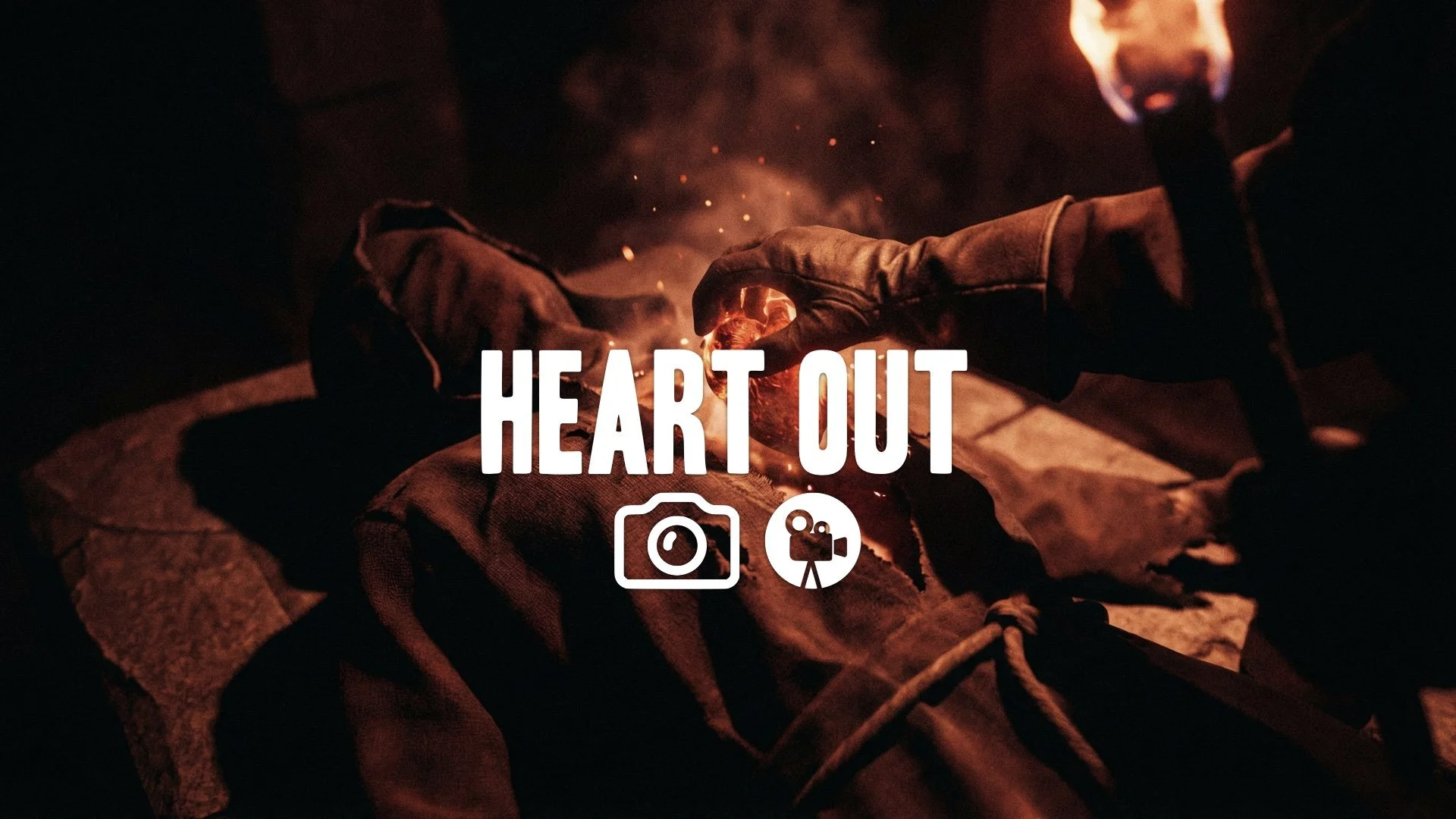 Close-up of a flaming heart being pulled from a cult victim's chest, lit by the ominous red torchlight. Horror, deep shadows, no music.