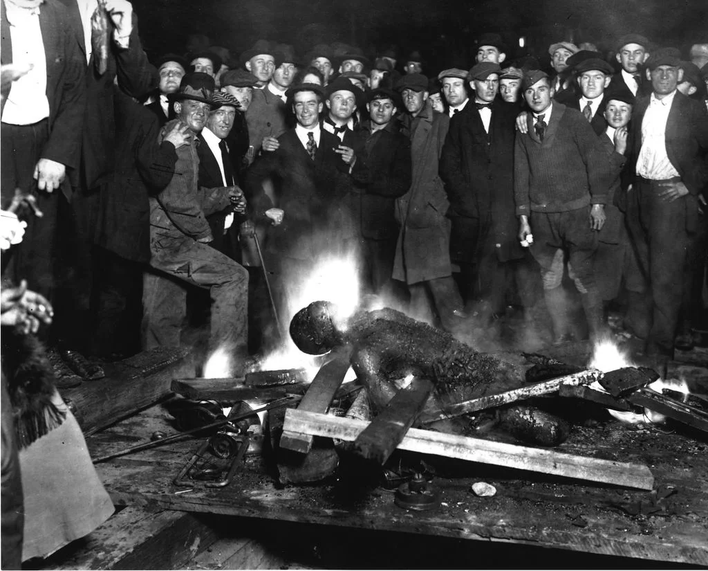 The scene of White on-lookers standing behind Will Brown’s burnt body – September 28, 1919