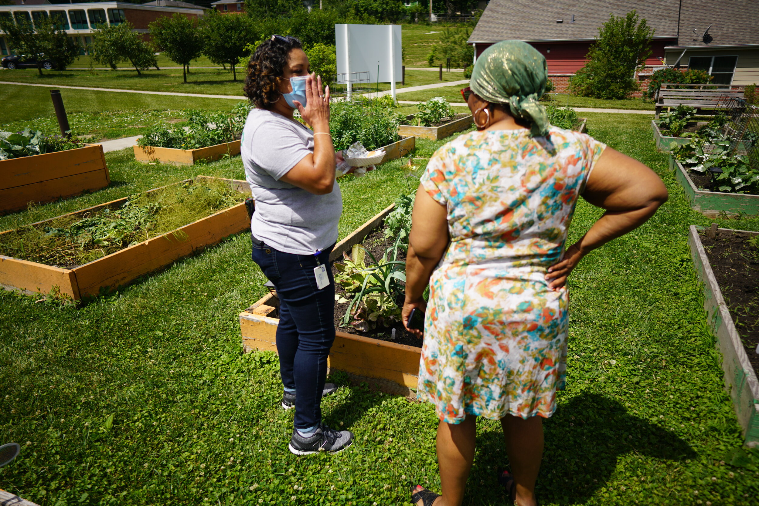 Orduña speaking with a resident while checking on the campus’ garden beds.