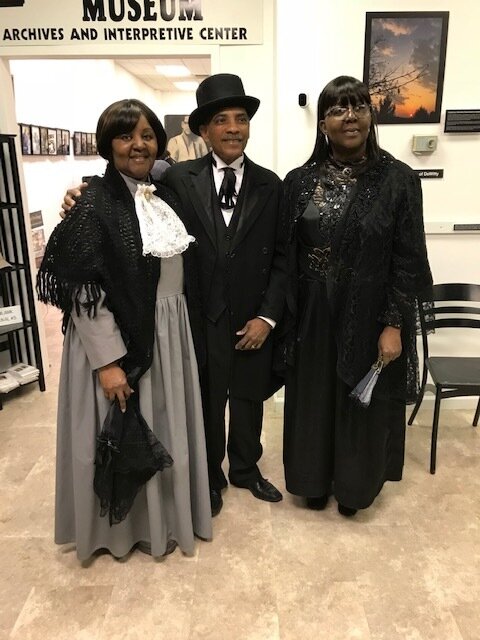 Harry Eure in costume, flanked by two actresses, at a Descendants of DeWitty reenactment. Photo credit: Eure family