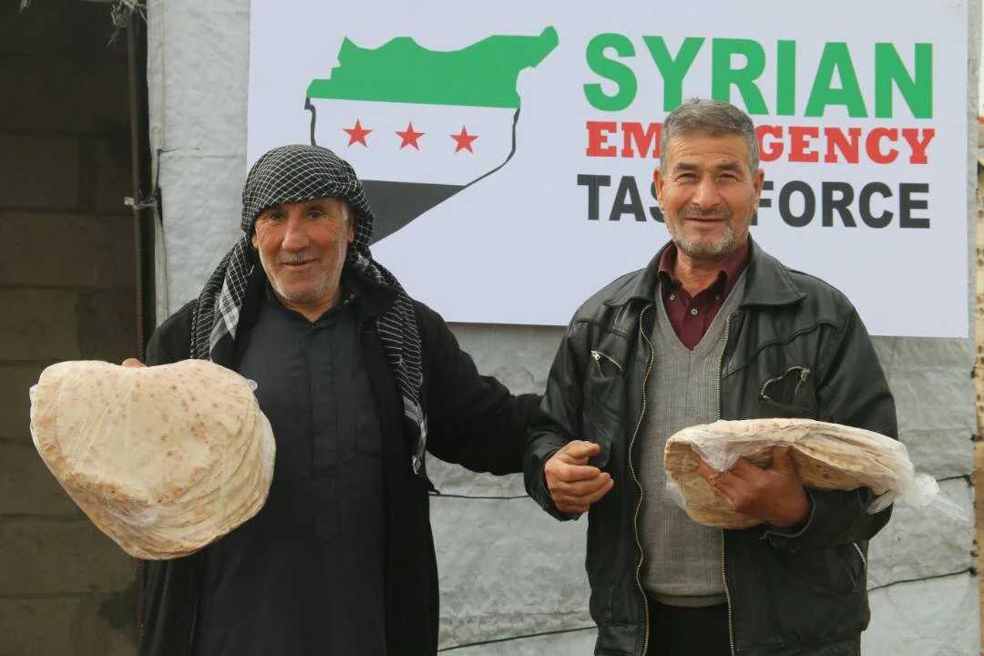 Syrian civilians smiling after receiving bread. SETF provides thousands of internaly displaced families with bread on a monthly basis