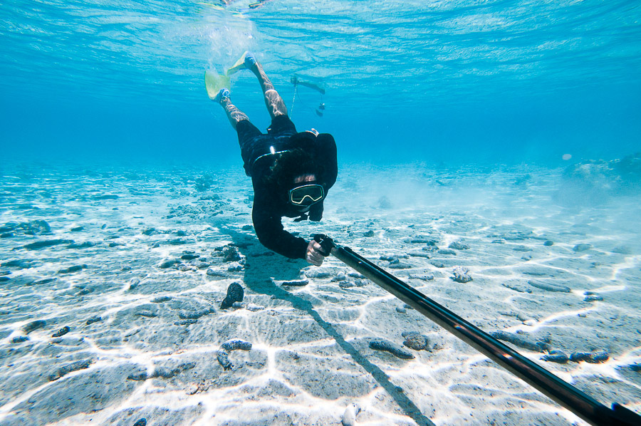 Spear fisherman hunting fish in a lagoon, Aitutaki, Cook Islands.